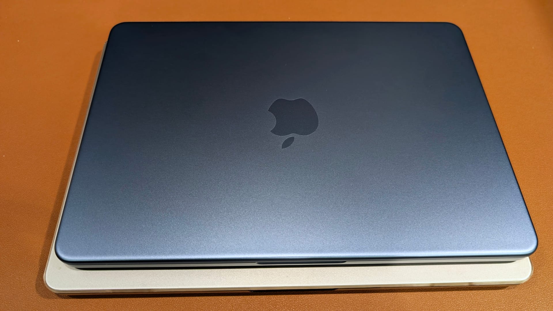 MacBook Neo on top of a MacBook Air. The Neo is a bit smaller than the M2 MacBook Air